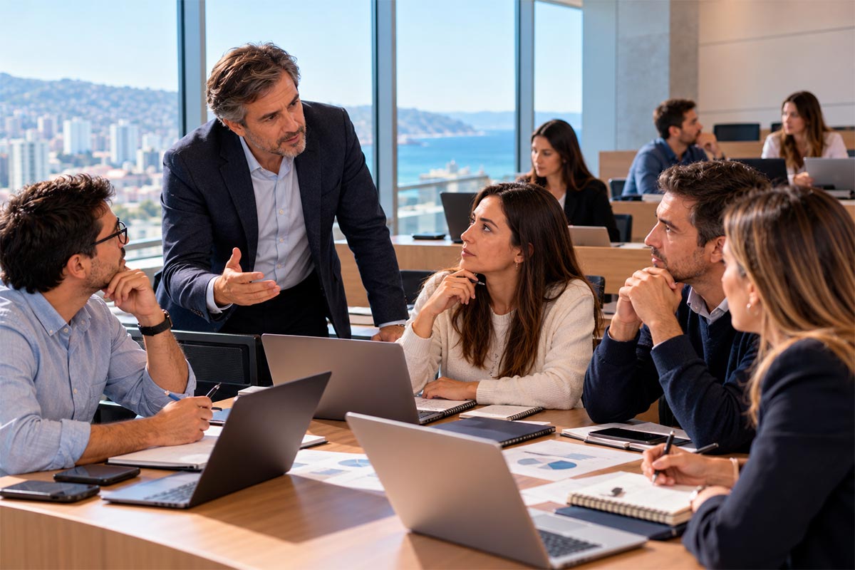 Docente y profesionales analizando un caso empresarial durante una sesión de formación en gestión.